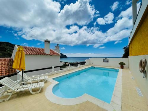 a pool on the balcony of a house with a view of the ocean at Casa de Praia in Almagreira
