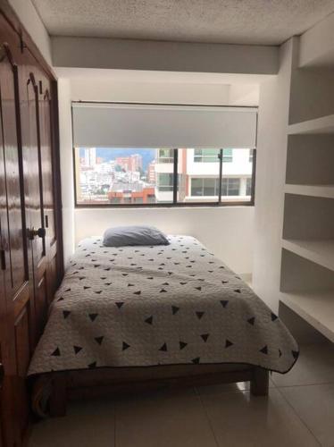 a bedroom with a bed with a window in it at Apartamento Manizales, excelente ubicación sector estadio in Manizales