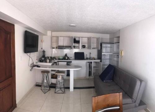 a kitchen with a couch and a table in a room at Apartamento Manizales, excelente ubicación sector estadio in Manizales