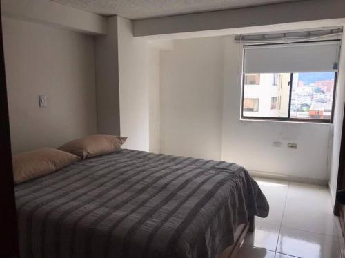 a bedroom with a bed with a window in it at Apartamento Manizales, excelente ubicación sector estadio in Manizales
