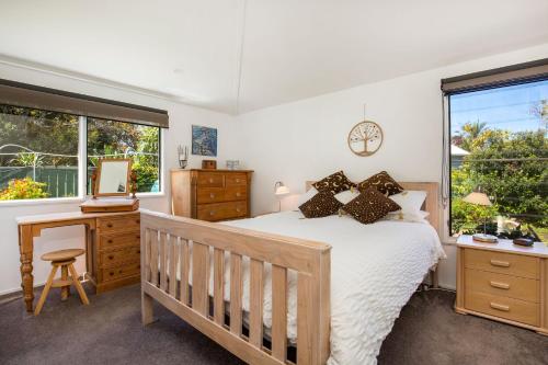 a bedroom with a bed and a desk and a window at Grey Gables Pet Friendly with Swimming Pool and Spa in Callala Bay