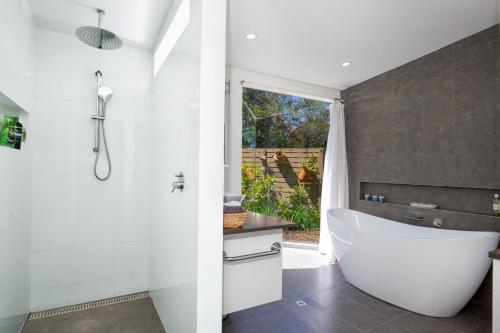 a bathroom with a white tub and a shower at Grey Gables Pet Friendly with Swimming Pool and Spa in Callala Bay