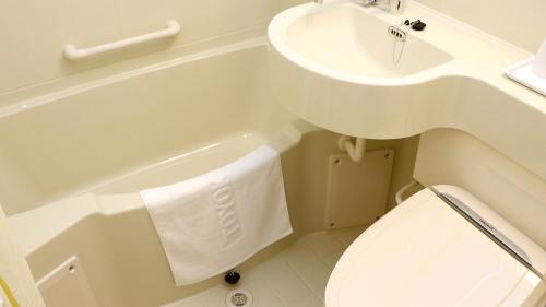 a bathroom with a sink and a tub and a toilet at Toyoko Inn Toyohashi eki Higashi guchi in Toyohashi