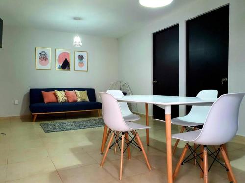 a living room with a table and white chairs at Depa/Loft Puebla SLP a 15 min del centro histórico in San Luis Potosí
