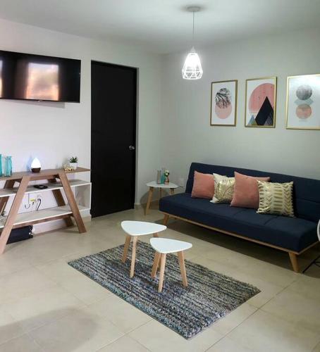 a living room with a blue couch and two chairs at Depa/Loft Puebla SLP a 15 min del centro histórico in San Luis Potosí