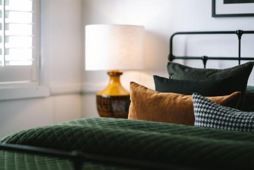 a bedroom with a green bed with a lamp at St Etienne Daylesford in Daylesford