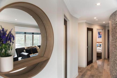 a round mirror on a wall in a living room at Amelia Daylesford in Daylesford