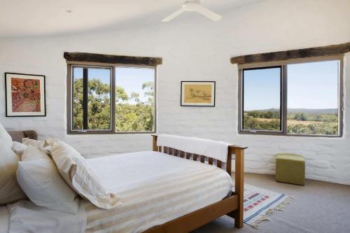 um quarto com uma cama e 3 janelas em Lithia Guest House - Daylesford Region em Hepburn Springs