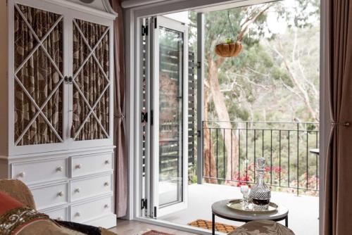 a room with a glass door leading to a balcony at Ascona - Hepburn Springs Daylesford in Hepburn Springs