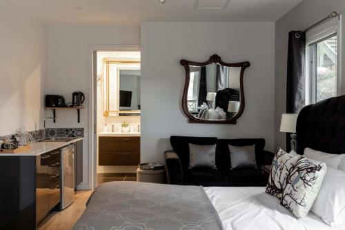 a bedroom with a bed and a sink and a mirror at Ascona - Hepburn Springs Daylesford in Hepburn Springs