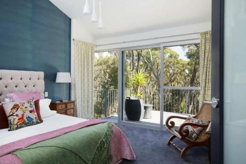 1 dormitorio con cama y ventana grande en The Bird House - Hepburn Springs Daylesford, en Hepburn Springs