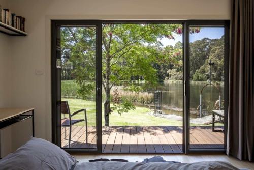 Schlafzimmer mit einer Glasschiebetür zur Terrasse in der Unterkunft Wombat Edge - Daylesford Region in Lyonville