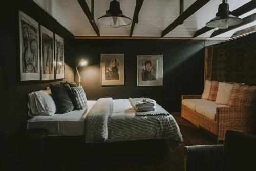 a bedroom with a bed and a chair in it at The Stables Daylesford in Daylesford