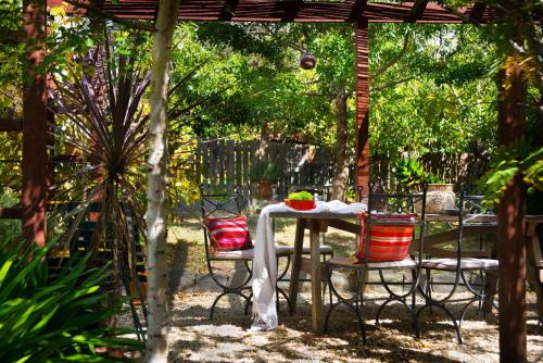 a table and chairs under a pergola in a garden at The Raglan Daylesford in Daylesford