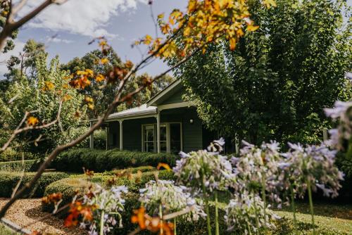 a house with flowers in front of it at Istana Lodge - Daylesford Region in Musk Vale