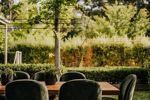 a wooden table and chairs with plants on it at Istana Lodge - Daylesford Region in Musk Vale