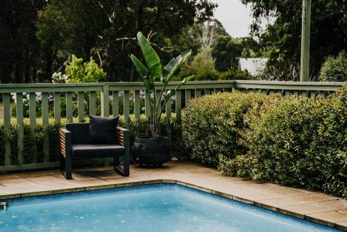 a chair and a chair next to a pool at Istana Lodge - Daylesford Region in Musk Vale