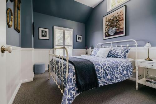 a blue bedroom with a bed and a desk at Candlebark Daylesford in Daylesford