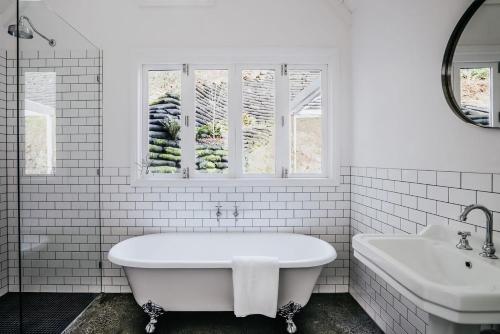 デイルスフォードにあるThe Green Door Daylesfordの浴槽と洗面台のある白いバスルーム