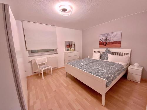 ein Schlafzimmer mit einem Bett und einem Stuhl darin in der Unterkunft Gästehaus Backes in Eppelborn