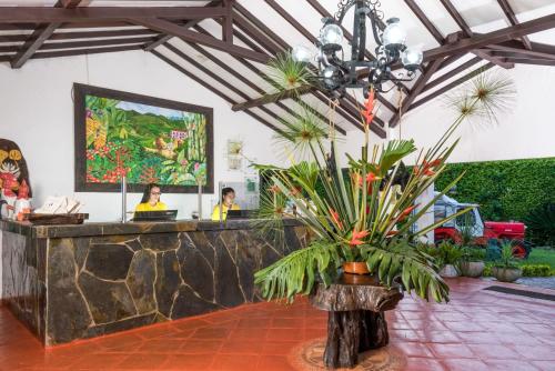 a lobby with a reception desk with a plant at Hotel Campestre Cafe Cafe in Montenegro