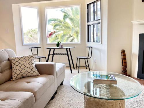 sala de estar con sofá y mesa de cristal en Modern & Cozy Gem ~ Walk to the Beach ~ Queen Beds, en Carpinteria