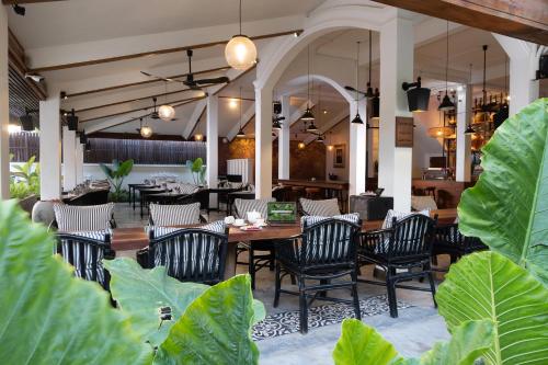 um restaurante com cadeiras e uma mesa e algumas plantas em The Urban em Siem Reap