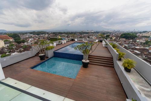 a balcony with a swimming pool on top of a building at Ascent Hotel & Cafe Malang in Malang
