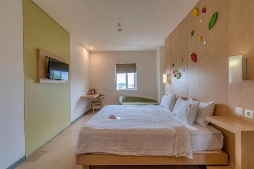 a bedroom with a large bed in a room at Ascent Hotel & Cafe Malang in Malang
