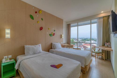Postel nebo postele na pokoji v ubytování Ascent Hotel & Cafe Malang