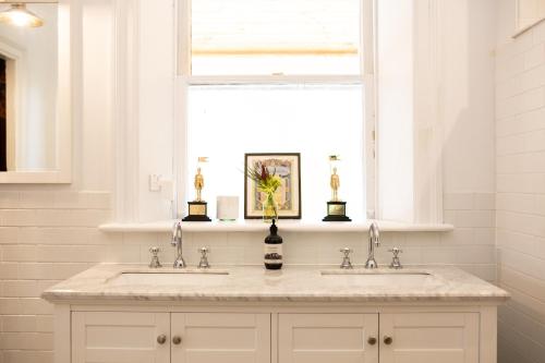 a white bathroom with two sinks and a window at Mount William Station in Willaura