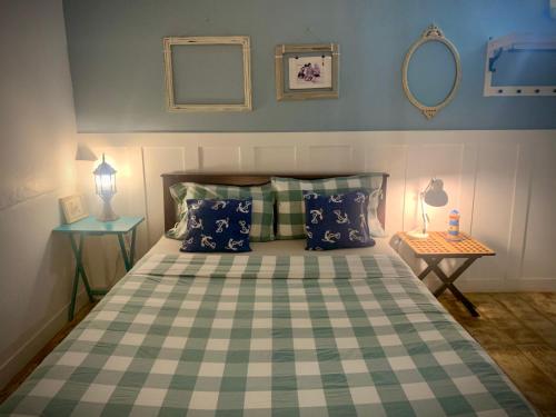a bedroom with a bed with a checkered bedspread and two lamps at Island House Rentals 40 in Ko Samed