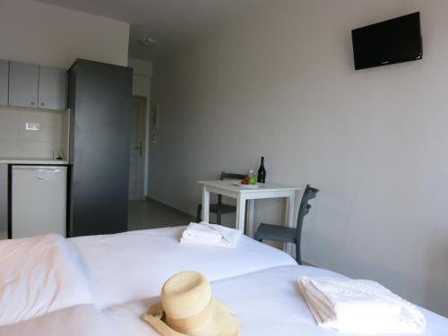 a room with two beds with a table and a kitchen at Amaryllis in Plataniás