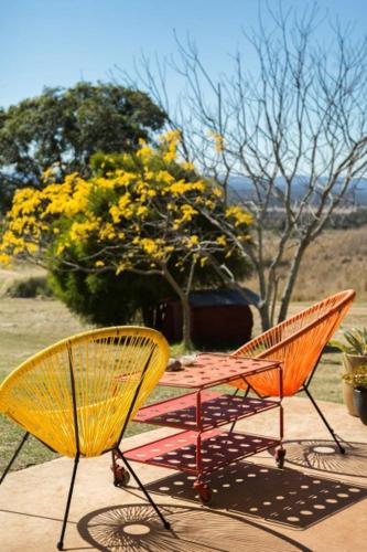Deux chaises assises à côté d'une table avec des fleurs jaunes dans l'établissement Deshons Country Retreat, à Kingaroy
