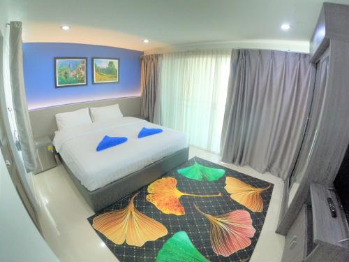 Dormitorio pequeño con cama y alfombra colorida en Poonsuk Place Hotel en Bangkok Noi