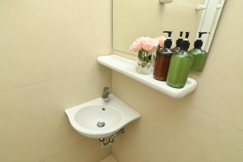y baño con lavabo y espejo. en Poonsuk Place Hotel en Bangkok Noi