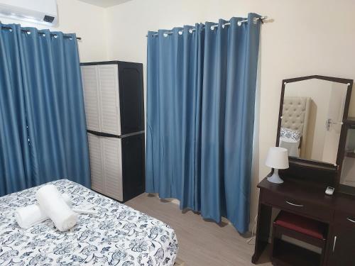 1 dormitorio con cortinas azules, 1 cama y espejo en 3 bed 3 bath Friendly, Friendship area, Fibre bdb, en Ángeles