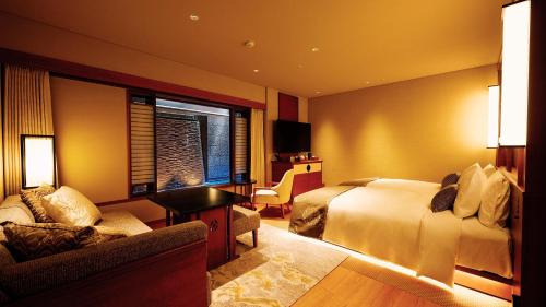 a hotel room with a bed and a couch at Sora Niwa Terrace Kyoto Bettei in Kyoto