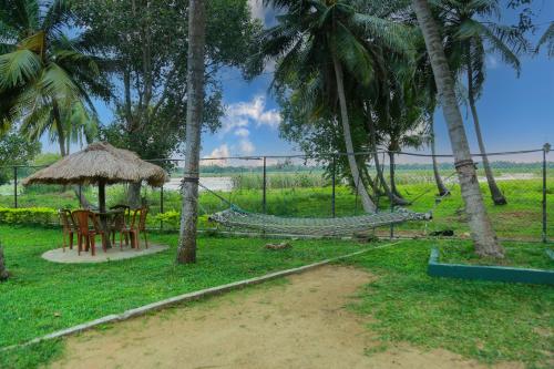 a picnic table in the middle of a lush green field at Lake Edge Holiday Inn in Tissamaharama