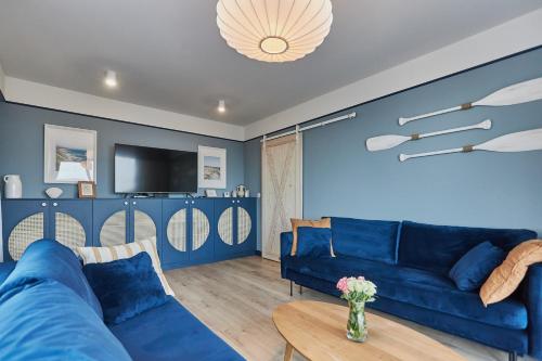 ein blaues Wohnzimmer mit einem blauen Sofa und einem Tisch in der Unterkunft Sofia Balticus Check-in in Misdroy