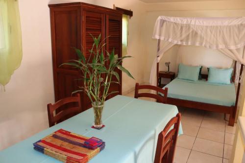 - une salle à manger avec une table et un lit dans l'établissement LA MARINA 5, à Ambodifotatra