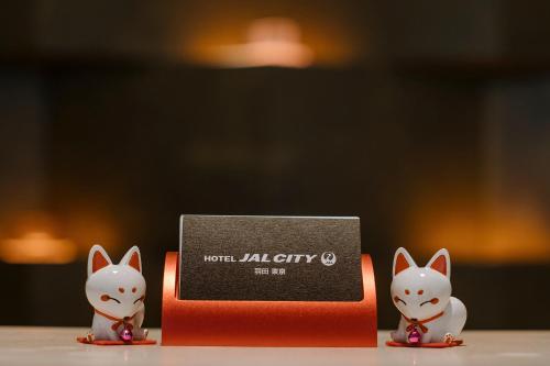 two small white cats are next to a box at Hotel JAL City Haneda Tokyo West Wing in Tokyo