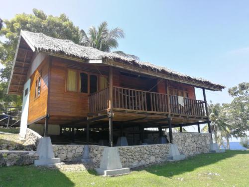 a large wooden house with a stone wall at UKCC (Ujung Karang Conference Center) in Sabong