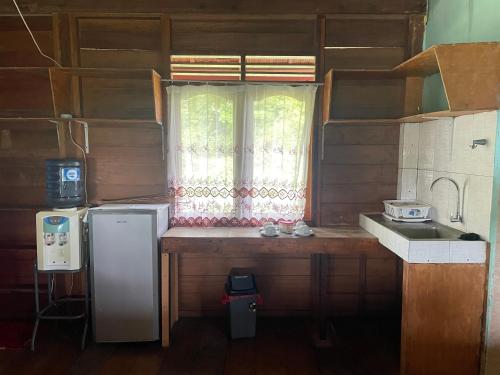 a kitchen with a refrigerator and a window at UKCC (Ujung Karang Conference Center) in Sabong