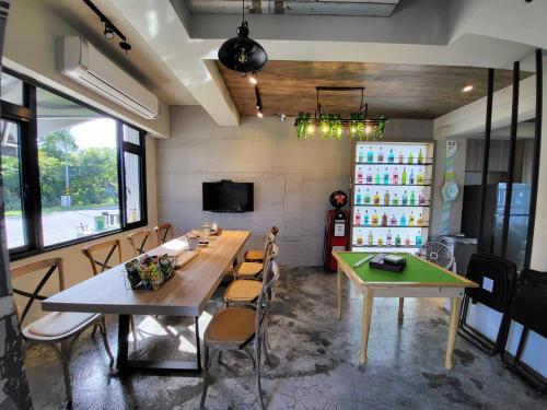 una sala da pranzo con tavolo, sedie e TV di Tipsy Snail a Sanxing