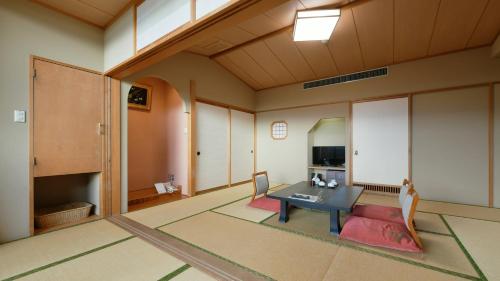 a living room with a table and a kitchen at Hotel Koryu in Fujikawaguchiko