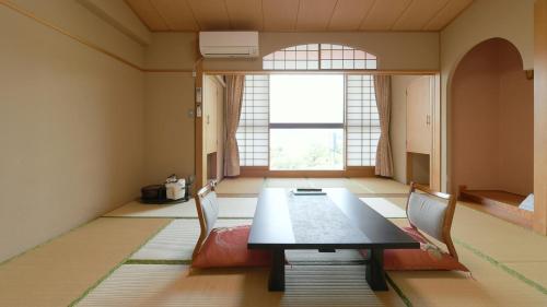 a dining room with a table and chairs and a window at Hotel Koryu in Fujikawaguchiko