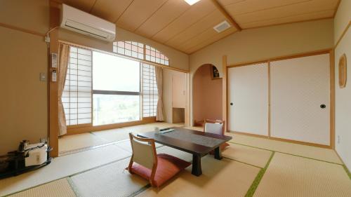 a dining room with a table and chairs and windows at Hotel Koryu in Fujikawaguchiko