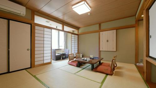 a room with a table and chairs in a room at Hotel Koryu in Fujikawaguchiko