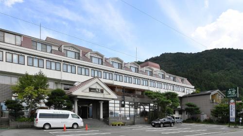 a large building with a van parked in a parking lot at Hotel Koryu in Fujikawaguchiko